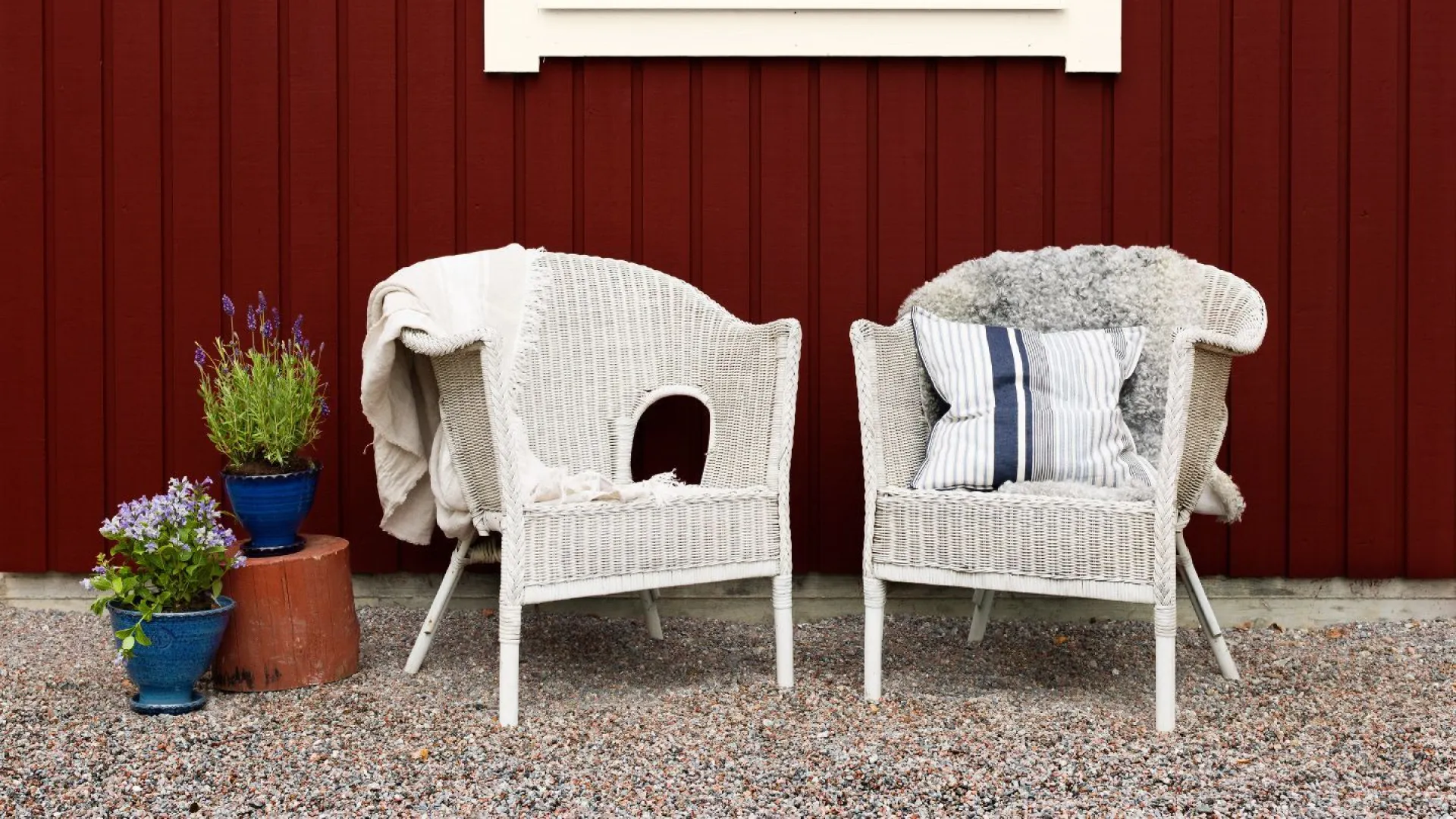 vita stolar framför rött hus